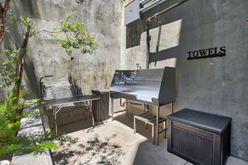 A small outdoor kitchen area with a grill and a table.